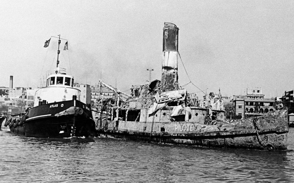 A wreck is towed away as part of the clearance operations in the Suez Canal (1 January 1957)